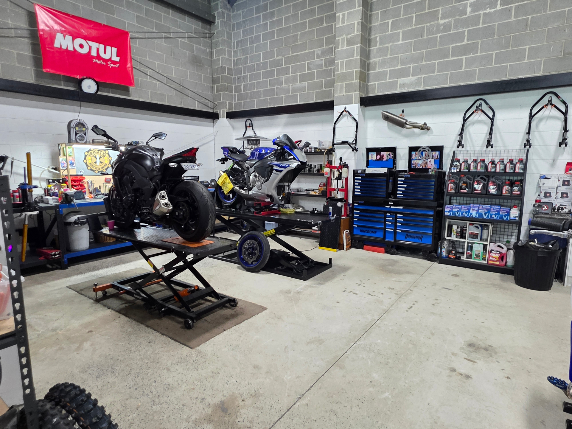 Two sportbikes on lifts inside Priesty's Motorcycle Garage