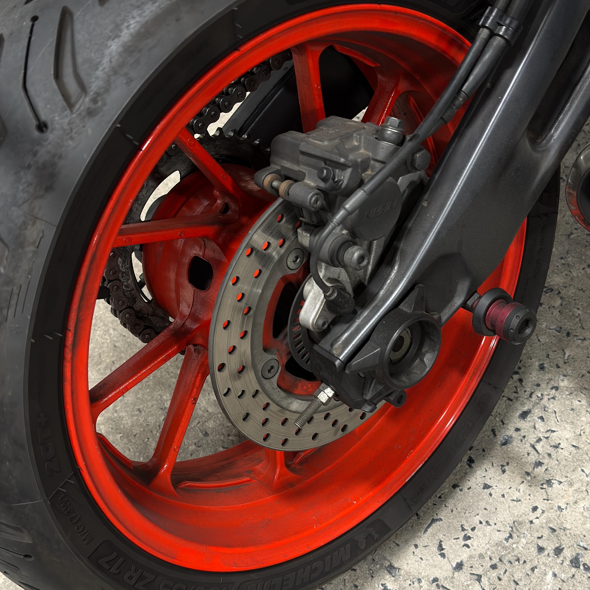 Red motorcycle wheel with brake disc close-up