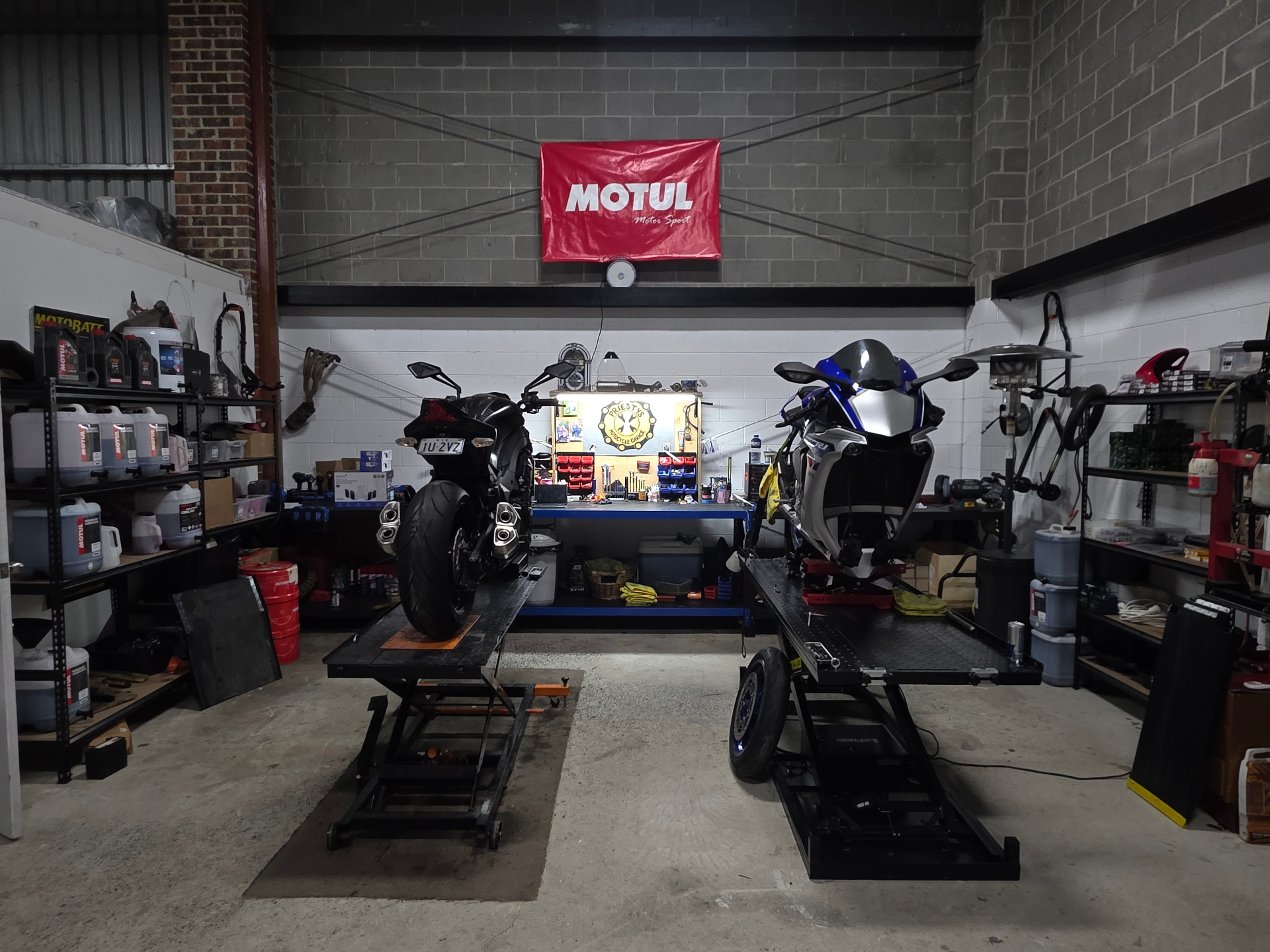 Front view of two sportbikes on lifts at Priesty's Motorcycle Garage